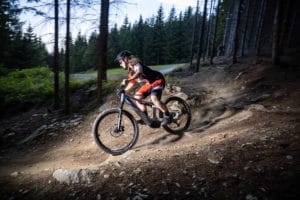 Woman with e-mountain bike on the descent