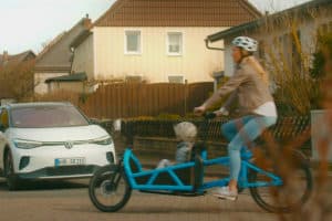 E-cargo bike and car meet at an intersection that is difficult to see for both of them.