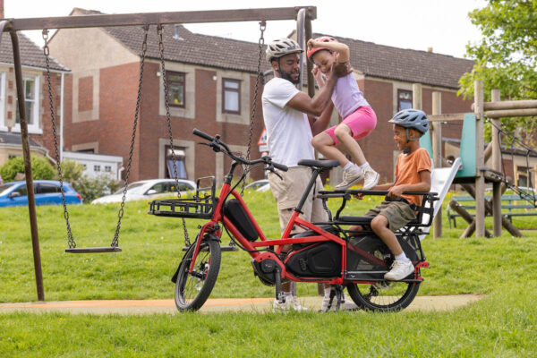 Riding with two children on the rear rack of the Tern Quick Haul Long ebike