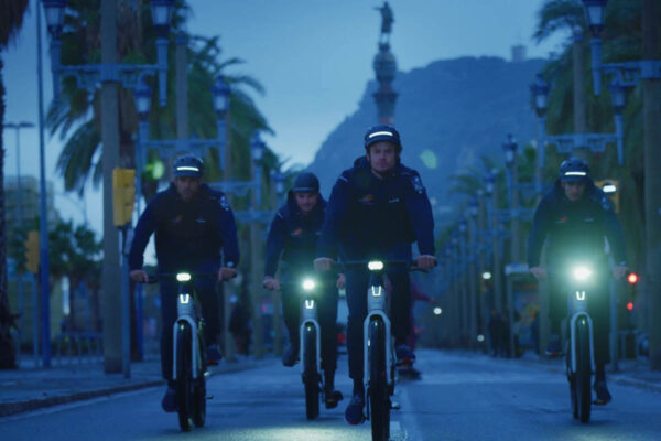 Group of ebikes with their lights on on a road