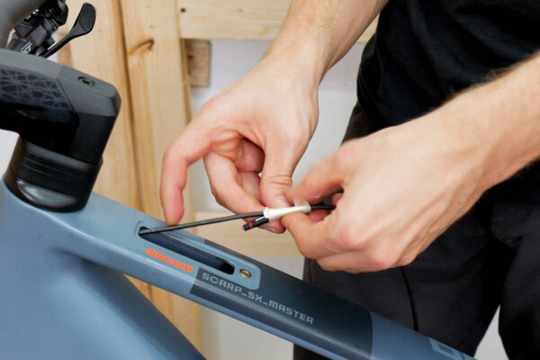 Routing the display cable in the bike frame during installation of the Bosch Purion 400 display on an ebike featuring the Bosch Smart System