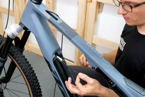 Routing the display cable in the bike frame during installation of the Bosch Purion 400 display on an ebike featuring the Bosch Smart System